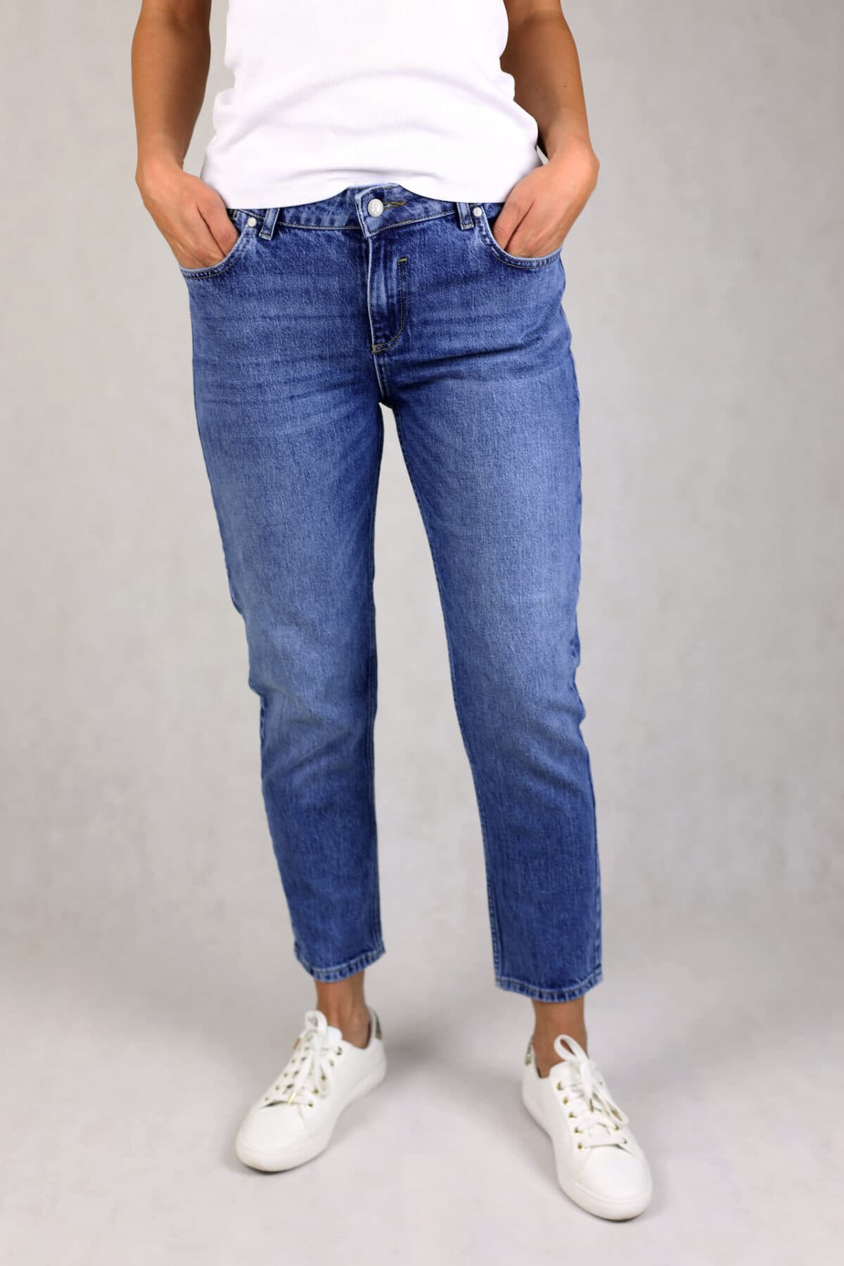 Niebieski jeansy z wysokim stanem w kolorze niebieskim, efekt prania, pięć kieszeni, zapinane na suwak.
